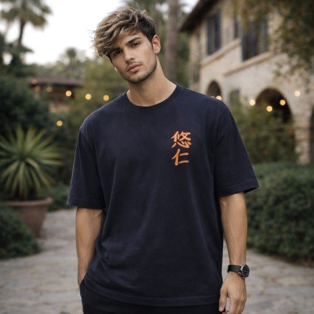 Male model wearing a black Jujutsu Kaisen oversized anime t-shirt with minimalist front artwork and casual oversized styling