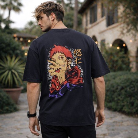 Male model wearing a black Jujutsu Kaisen oversized anime t-shirt with minimalist front artwork and casual oversized styling