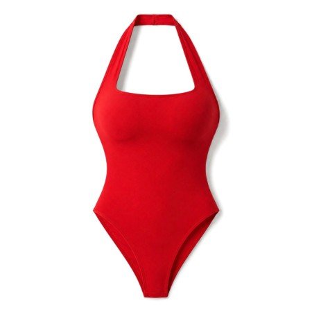Woman wearing a cherry red halter neck bodysuit styled with black leather shorts