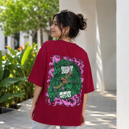 Male model wearing a maroon One Piece oversized t-shirt featuring a pirate emblem chest graphic and relaxed streetwear fit.