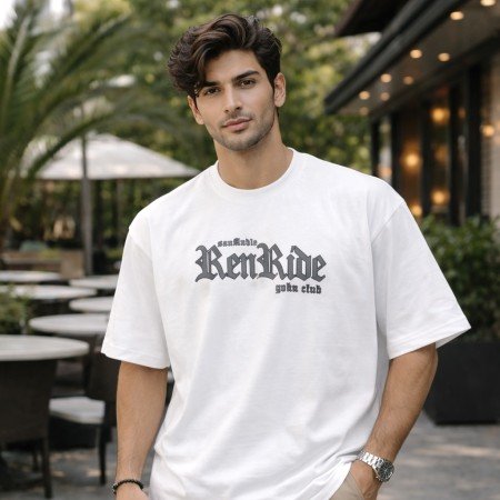 Male model wearing a white oversized anime graphic t-shirt with front text print and casual oversized styling.
