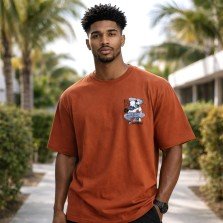 Female model wearing a rust orange Gojo Satoru oversized anime t-shirt with relaxed streetwear styling