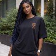 Female model wearing a black Jujutsu Kaisen oversized t-shirt featuring a Japanese-inspired chest graphic and relaxed streetwear fit