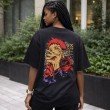 Female model showcasing the back view of a black Jujutsu Kaisen graphic t-shirt with a large Yuji Itadori anime character print