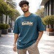 Male model wearing a teal blue Dragon Ball oversized t-shirt featuring Goku-inspired typography and a relaxed streetwear fit