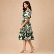 Side profile of green floral print midi dress featuring gathered waist and short puff sleeves