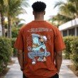 Female model wearing a rust orange Gojo Satoru oversized anime t-shirt with relaxed streetwear styling