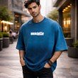 Men’s washed blue oversized crew neck graphic T-shirt front view featuring minimalist streetwear logo print