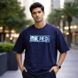 Male model wearing a navy blue oversized One Piece anime graphic t-shirt featuring a front logo print and relaxed fit.