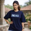 Female model wearing a navy blue oversized One Piece graphic t-shirt with anime-inspired front artwork and loose-fit styling.