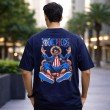 Male model showcasing the back view of a navy blue oversized One Piece t-shirt with a large Luffy anime character graphic print.