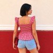 Back view of red gingham top with smocked back panel and flutter sleeves