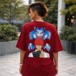 Back view red oversized Death Note anime unisex T-shirt with Ryuk and Light Yagami graphic worn by female model