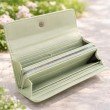Interior of sage green long wallet for women featuring multiple card slots and compartments