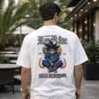 Male model showcasing the back design of a white oversized Goku graphic t-shirt featuring detailed anime artwork and statement back print.