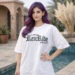 Female model wearing a white oversized Goku anime graphic t-shirt featuring bold front typography and a relaxed streetwear fit.
