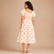 Back view of women's cream midi dress with red heart pattern and gathered waist