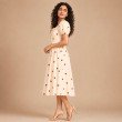 Side view of cream heart print midi dress featuring short puff sleeves and a flowy skirt