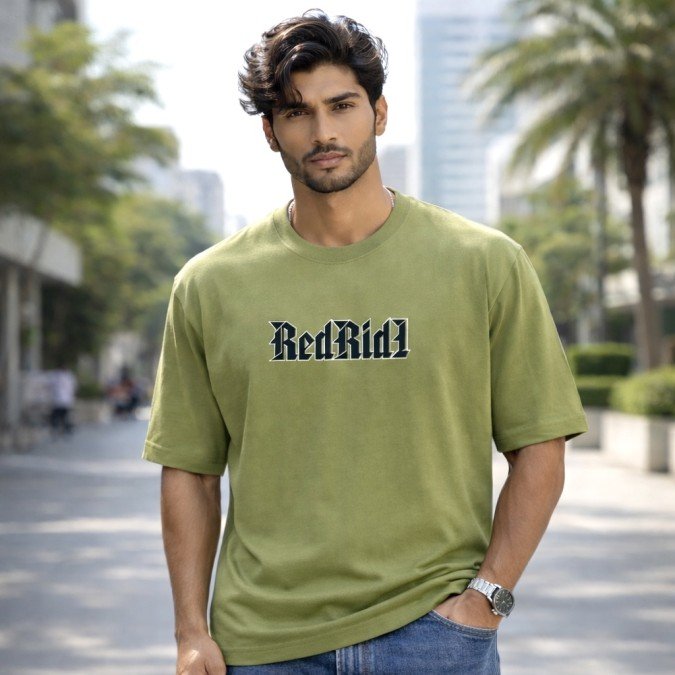 Male model wearing an olive green Dragon Ball Z oversized t-shirt featuring Vegeta-inspired front typography.