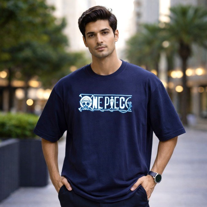 Male model wearing a navy blue oversized One Piece anime graphic t-shirt featuring a front logo print and relaxed fit.